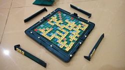 A near-ending game board, tiles and racks of t...